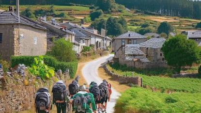 Pilgrims approaching the village of Gonzar, Galicia, Spain, along the Camino Francés