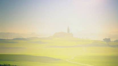 Camino Francés trail with San Juan de Ortega, northern spain, in the distance, photographic, sunshine