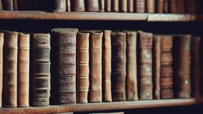 A bookshelf full of old books about the Camino de Santiago