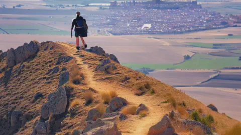 hikers ascent to the Alto Mostelares with Castrojeriz distance below, Northern Spain