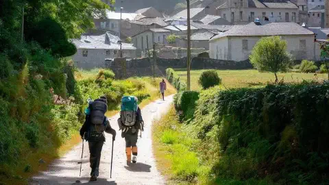 Pilgrims arrive at Calvor along the Camino Francés Modern Pilgrims arriving on foot at Calvor along the Camino Francés, The French Way of the Camino de Santiago