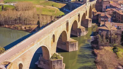 Puente De La Reina Romaneque Medieval Bridge Spain Puente de la Reina, medieval bridge, romanesque, in Spain, in the distance, ariel view, on a sunny day